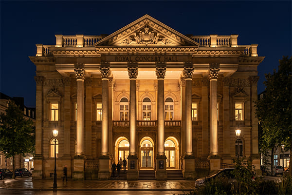 A building facade lit with a layered approach, highlighting columns and details